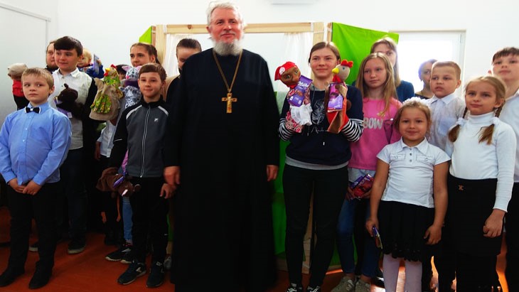 Протоиерей о. Игорь и дети воскресной школы во время представления.